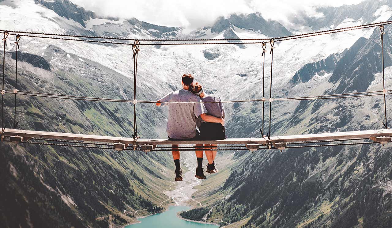 Getting the love you want - a couple on a bridge miles above a lake and mountains