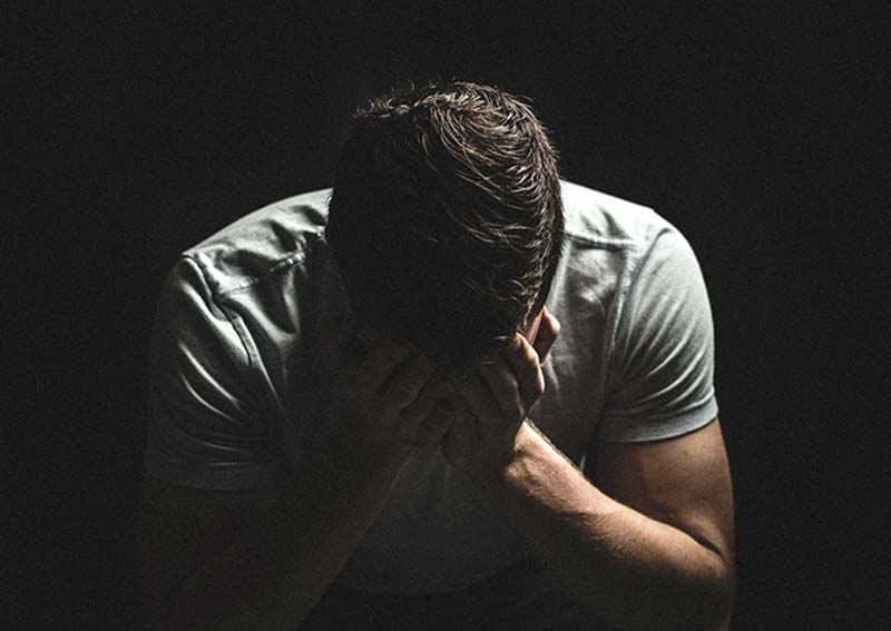 CBT Therapy for Depression showing a man with his head in his hands